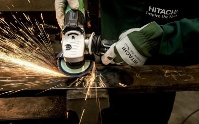 Close-up of a skilled worker using a grinder with sparks flying in a metal workshop.